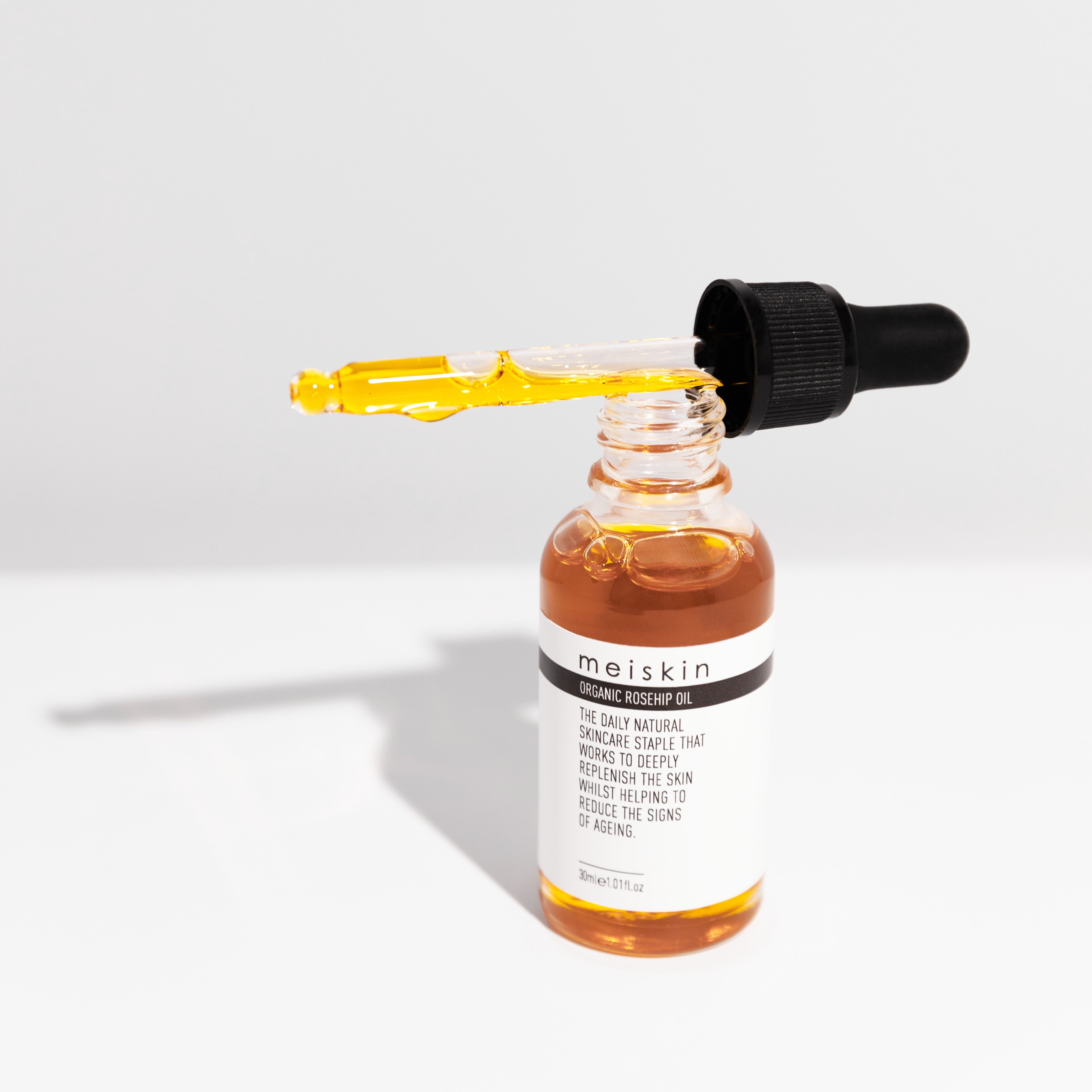Meiskin skincare serum bottle organic rosehip oil with dropper on a white background