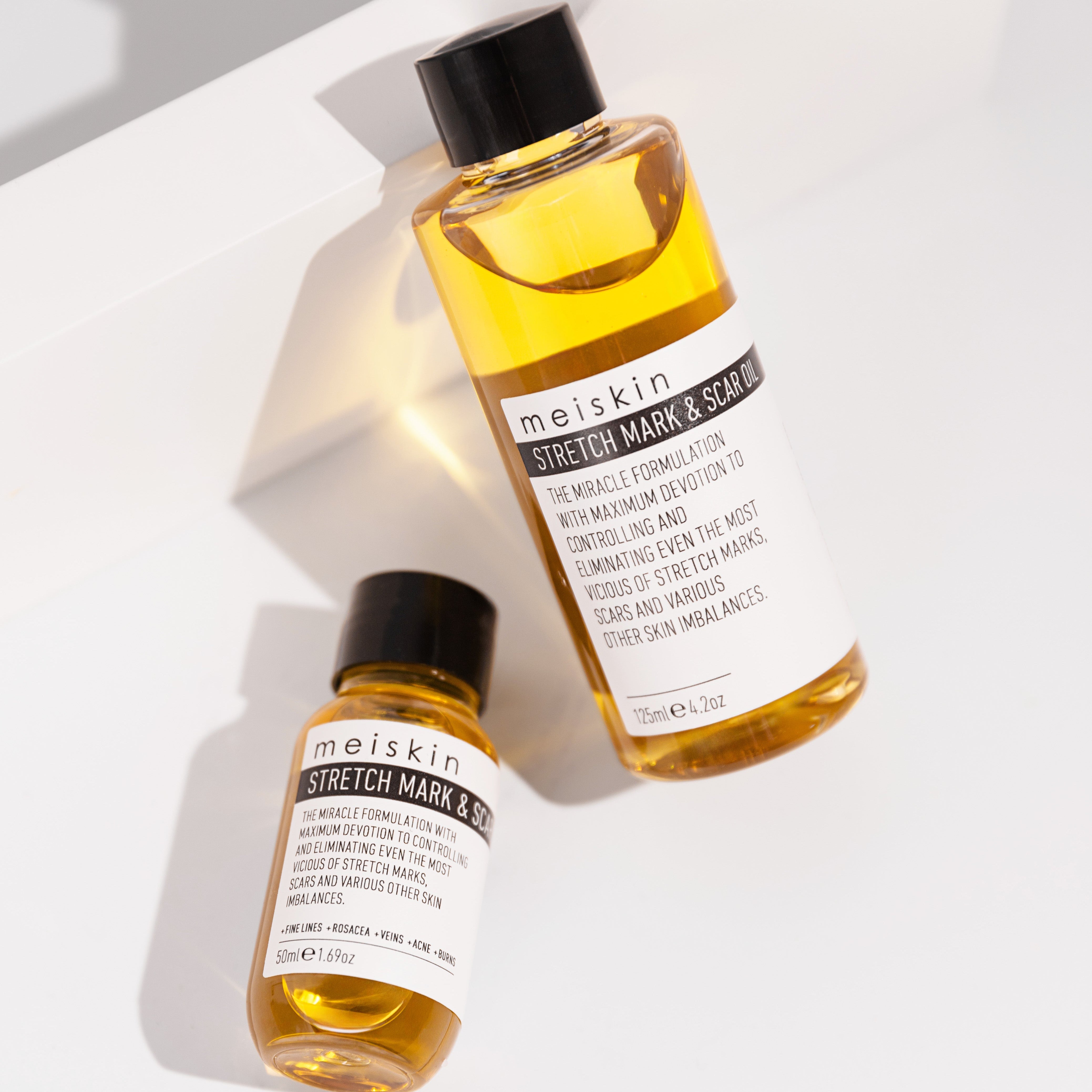 Two bottles of Meiskin Stretch Mark & Scar Lotion on a light background